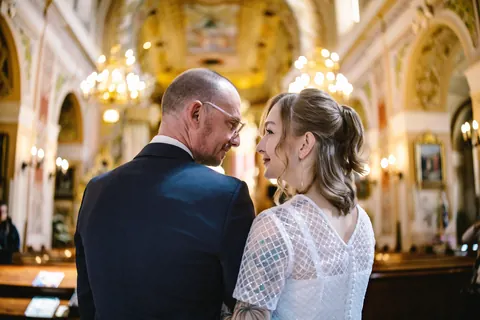Para młoda spogląda na siebie we wnętrzu kościoła