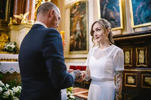 Para młoda trzyma się za ręce podczas ceremonii